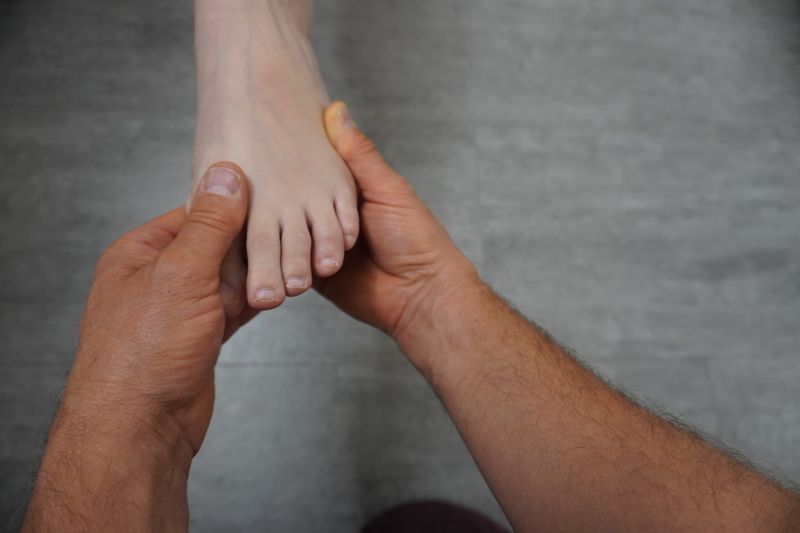 Ein Mann hält einen Fuß in den Händen