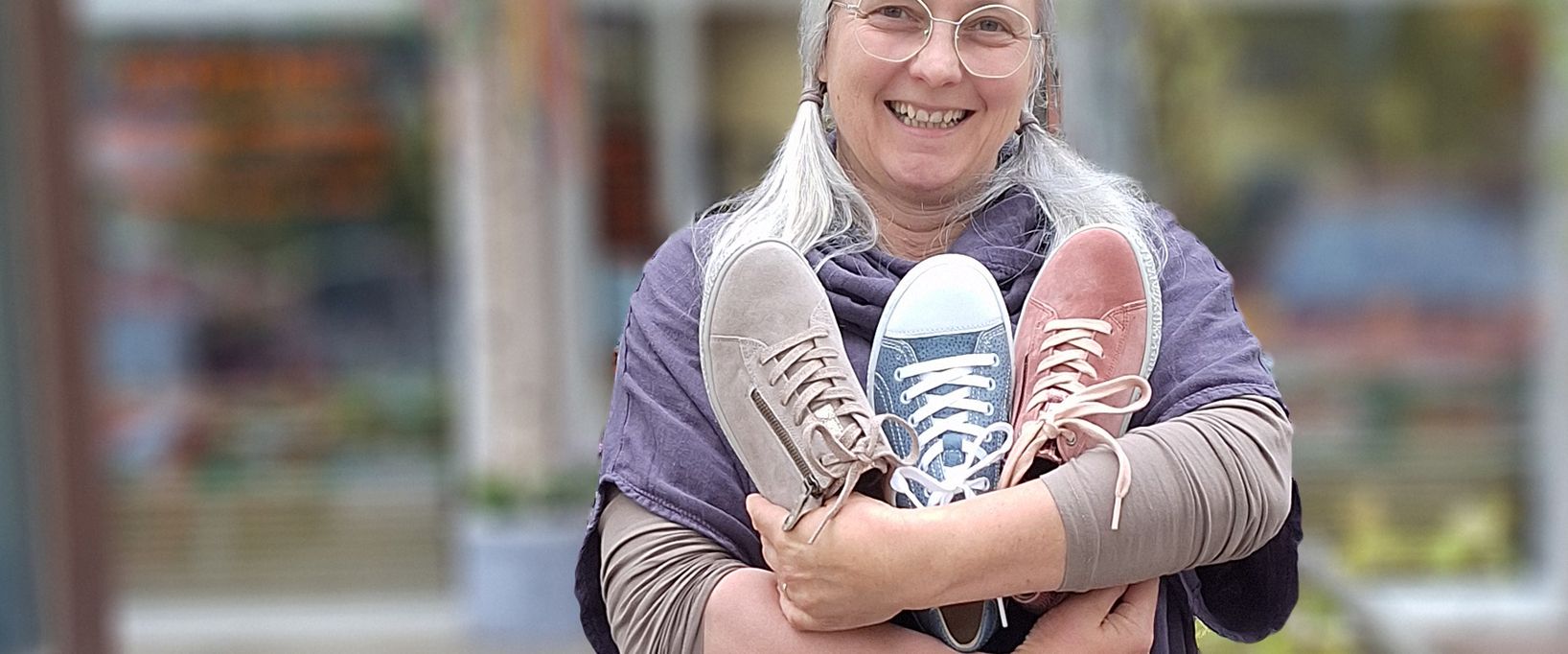 Elisabeth Kotzbeck hält drei Schuhe in den Armen